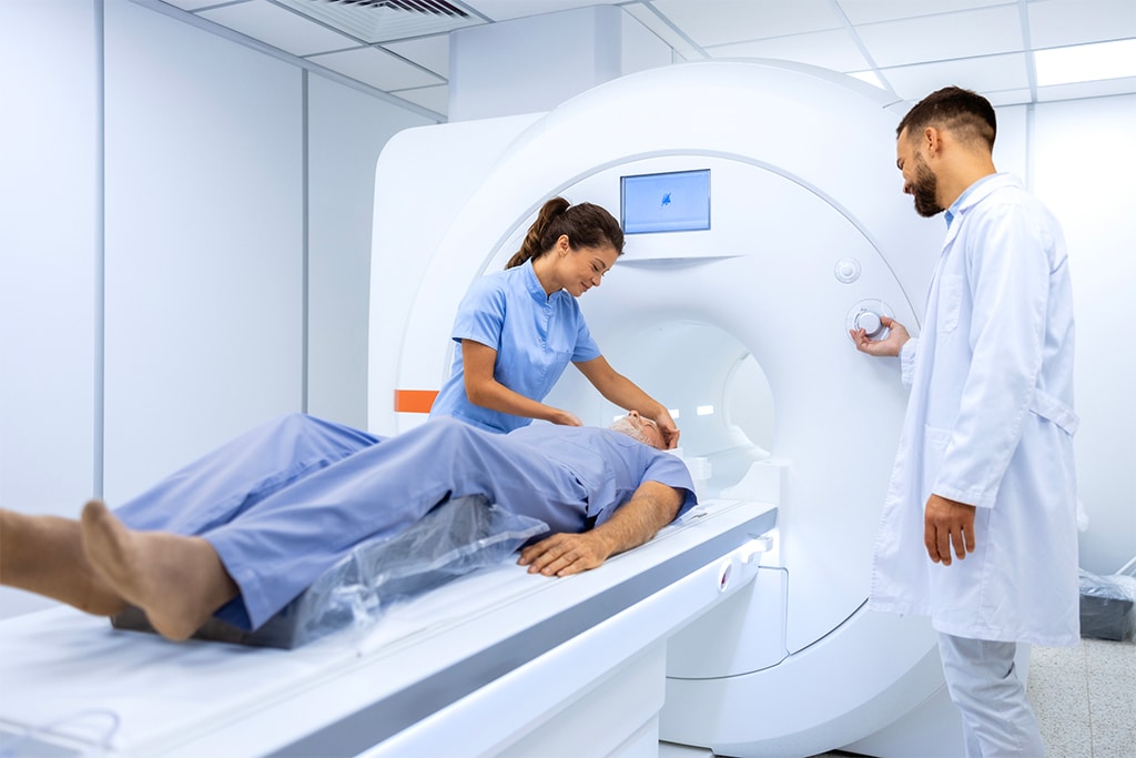 Female doctor assisting senior patient while doing MRI scan in medical examination room