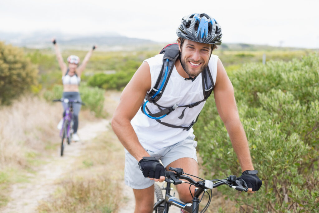 Fit attractive couple cycling on mountain trail