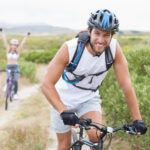 Fit attractive couple cycling on mountain trail